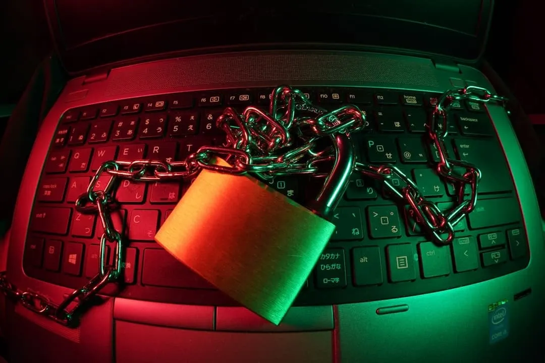 Hangslot met ketting op een laptoptoetsenbord, uitgelicht in rood en groen licht