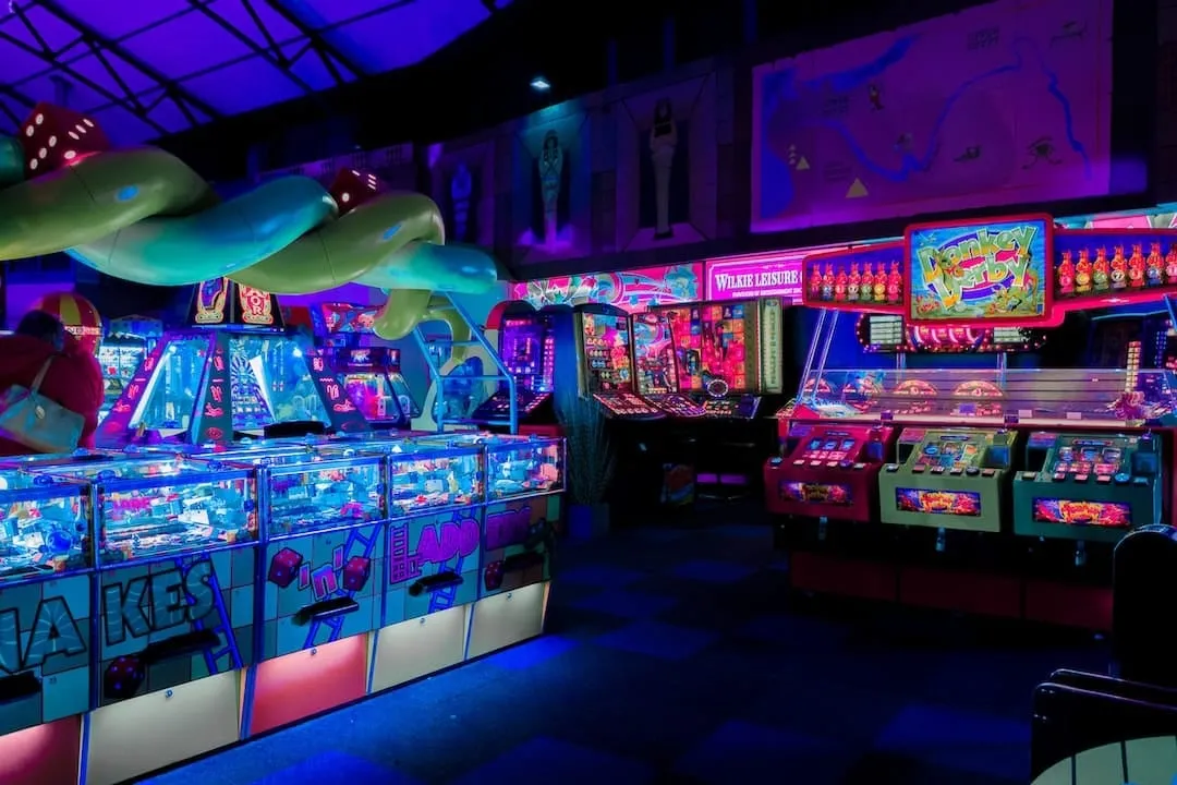 Speelhal met rijen gokkasten in paars en blauw neonlicht