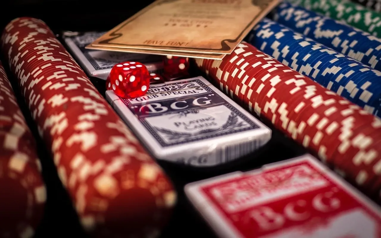 Stapels pokerfiches met twee pakjes speelkaarten en een rode dobbelsteen