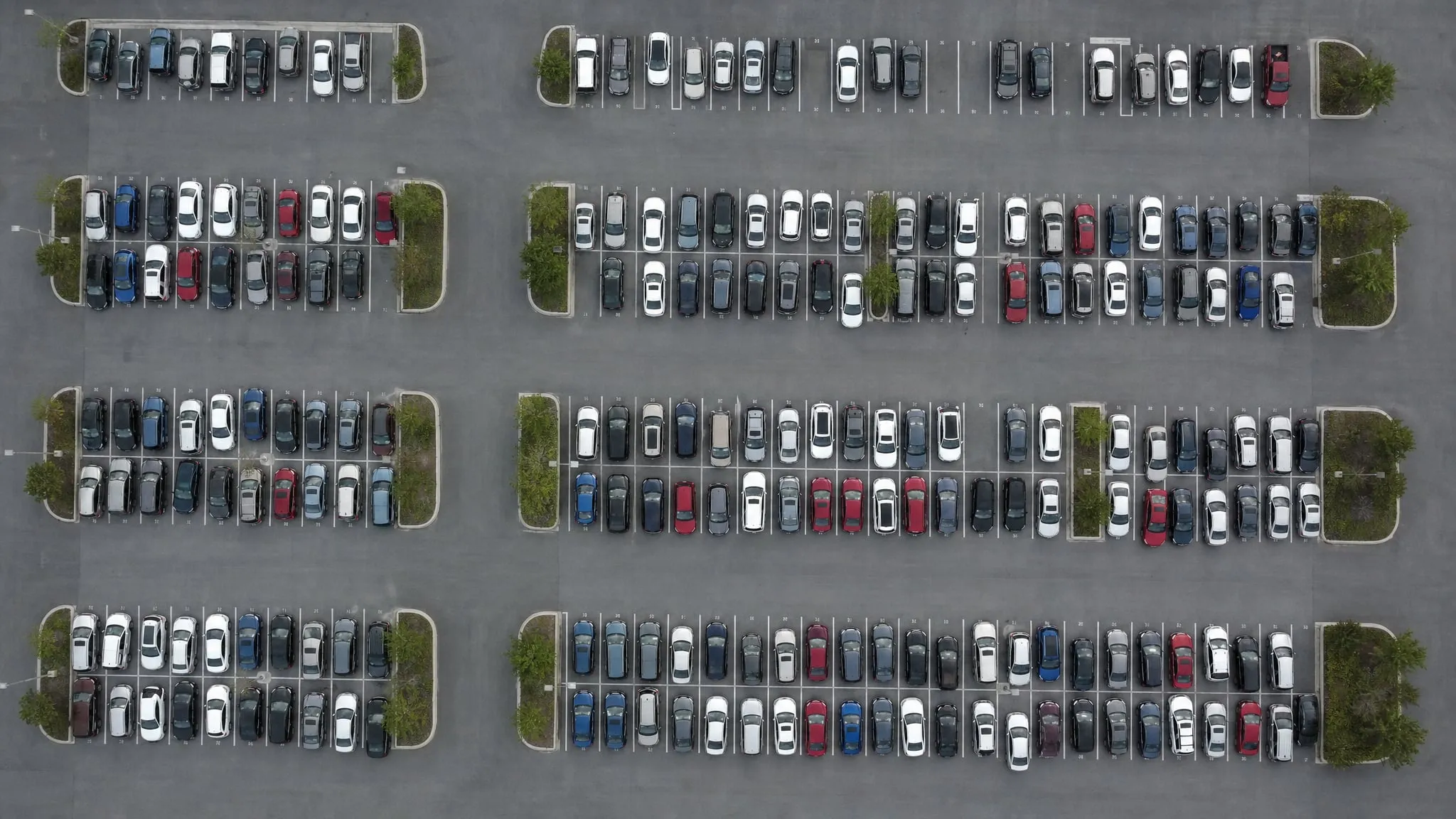 Luchtfoto van een vol parkeerterrein met rijen geparkeerde auto's